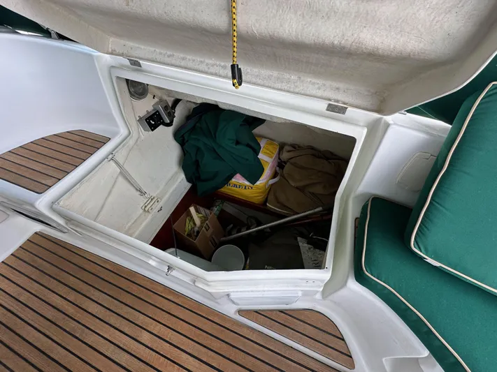 Knot Inspired Yacht Photos Pics Open storage compartment on a 2002 Beneteau 411 sailboat, with various items inside.