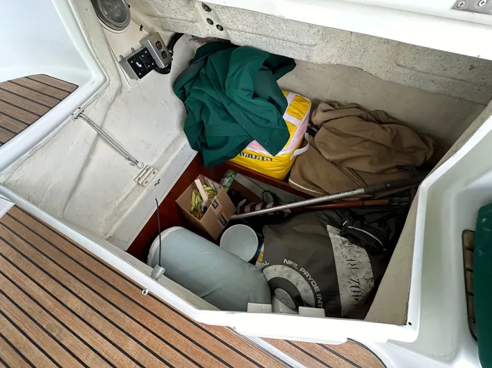 Knot Inspired Yacht Photos Pics Storage compartment of a 2002 Beneteau 411 sailboat with various items and equipment.