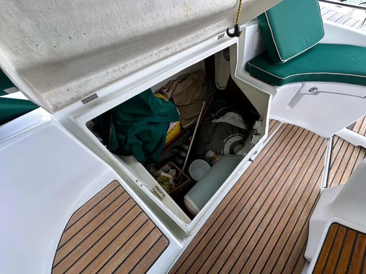 Knot Inspired Yacht Photos Pics Storage compartment on 2002 Beneteau 411 sailboat with teak deck and green seating.
