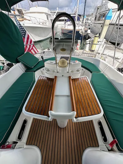 Knot Inspired Yacht Photos Pics Beneteau 411 sailboat cockpit, 2002 model, featuring teak flooring and green cushioned seating.