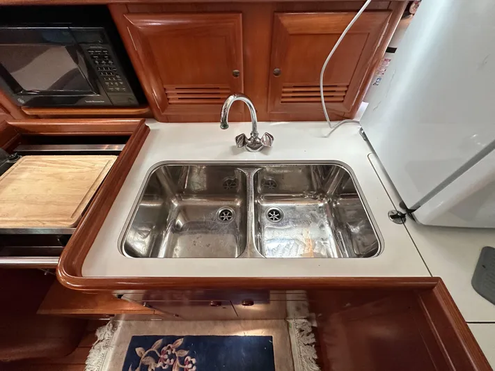 Knot Inspired Yacht Photos Pics Double sink in 2002 Beneteau 411 yacht kitchen with wooden cabinetry.