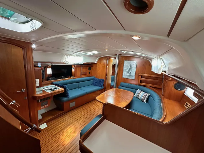 Knot Inspired Yacht Photos Pics Interior of 2002 Beneteau 411 yacht with wooden finish and blue seating.