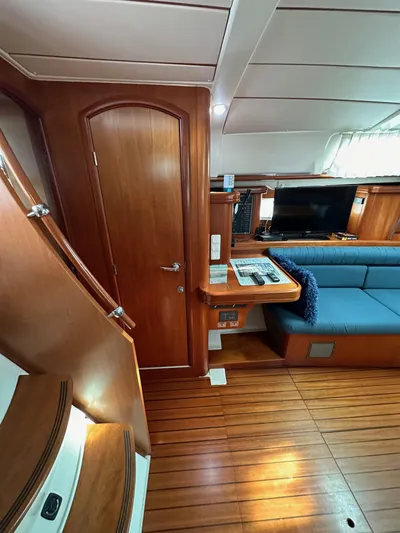 Knot Inspired Yacht Photos Pics Interior of 2002 Beneteau 411 sailboat with wooden flooring and blue seating.