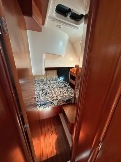 Knot Inspired Yacht Photos Pics Cozy cabin interior of 2002 Beneteau 411 sailboat with patterned bedding and wooden finishes.