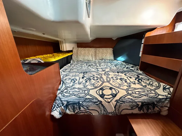 Knot Inspired Yacht Photos Pics Cozy cabin interior of 2002 Beneteau 411 sailboat with patterned bedding and wooden shelves.