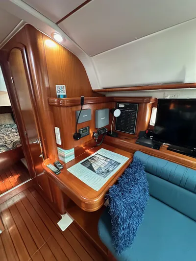Knot Inspired Yacht Photos Pics Interior of 2002 Beneteau 411 yacht with navigation station and cozy seating area.