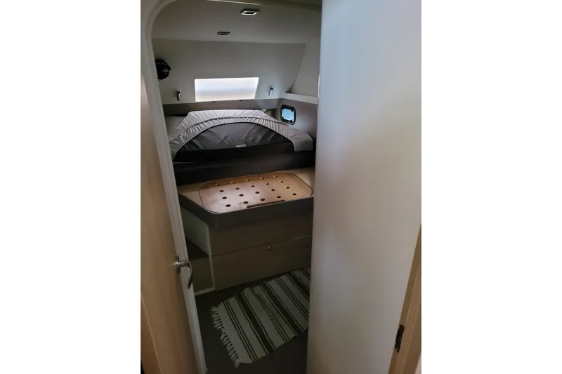  Yacht Photos Pics Cozy cabin interior of 2019 Bali 4.3 catamaran with bed and striped rug.