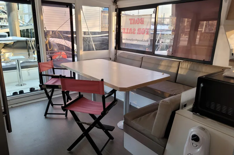  Yacht Photos Pics Interior of 2019 Bali 4.3 catamaran with dining area and "Boat for Sale" sign.