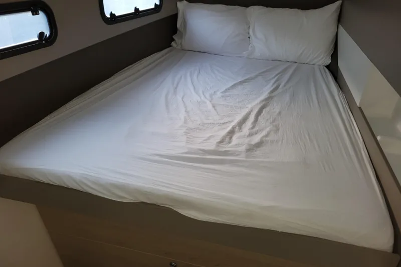  Yacht Photos Pics Bed inside a 2019 Bali 4.3 model, featuring white linens and compact design.