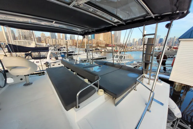  Yacht Photos Pics 2019 Bali 4.3 yacht with spacious deck, docked in a marina with city skyline.