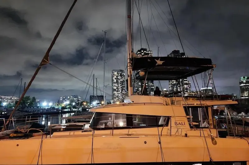  Yacht Photos Pics 2019 Bali 4.3 catamaran docked at night with city skyline backdrop.