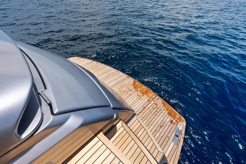  Yacht Photos Pics 2024 Pershing 6X yacht with sleek design and wooden deck on open water.