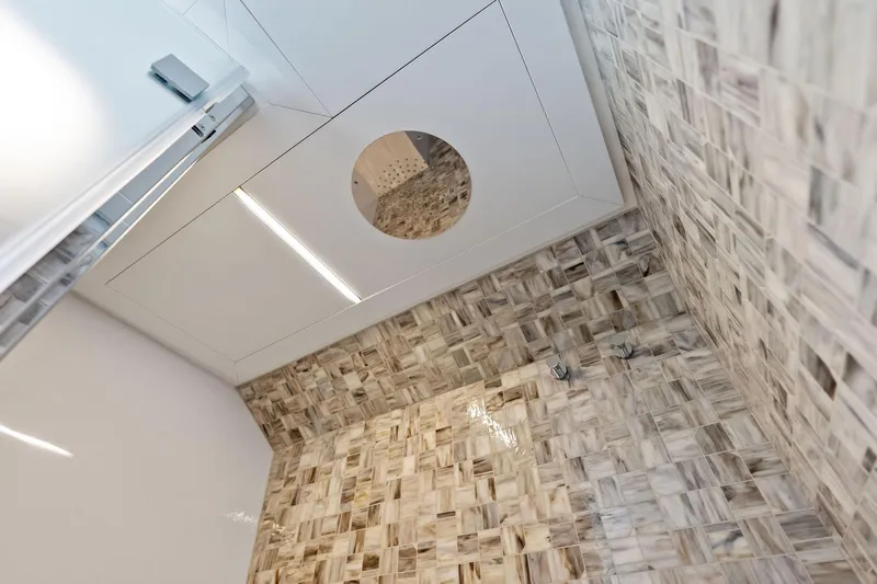  Yacht Photos Pics Luxurious 2024 Pershing 6X yacht bathroom with elegant tiled walls and modern fixtures.