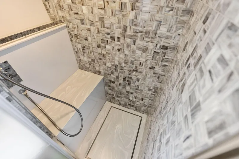  Yacht Photos Pics Luxurious shower area in 2024 Pershing 6X yacht with elegant tile design.