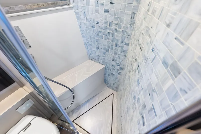  Yacht Photos Pics Luxurious bathroom interior of 2024 Pershing 6X yacht with elegant tiled walls.