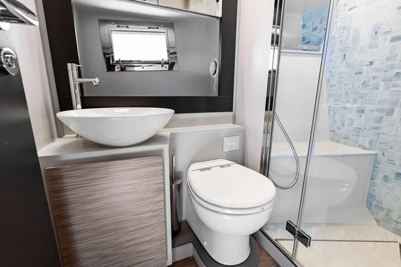  Yacht Photos Pics Luxurious bathroom in 2024 Pershing 6X yacht with modern fixtures and glass shower.