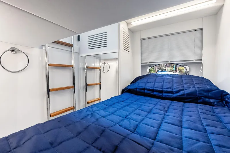  Yacht Photos Pics 2024 Pershing 6X yacht interior cabin with blue bedding and modern design.