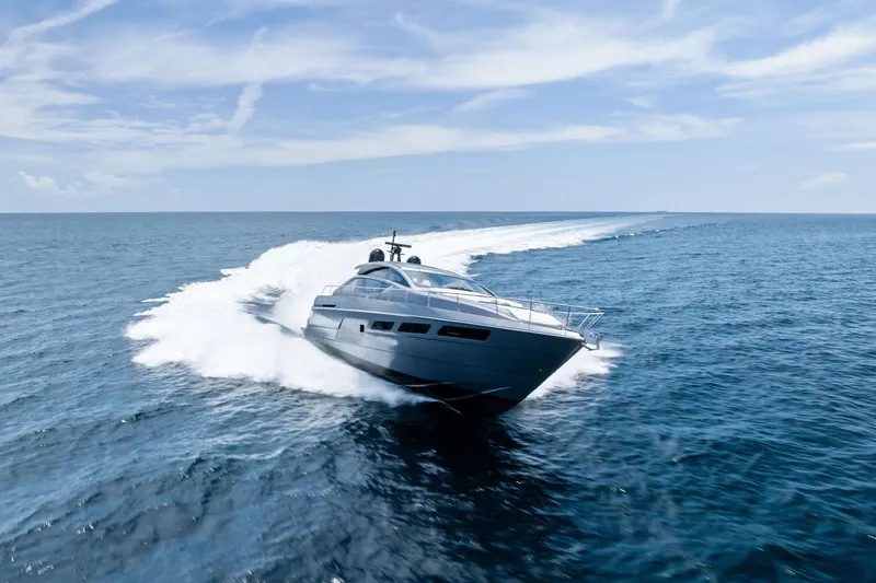  Yacht Photos Pics 2024 Pershing 6X yacht cruising swiftly on open ocean under clear blue sky.