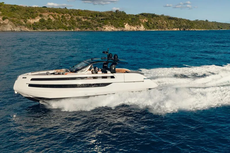  Yacht Photos Pics 2025 Invictus TT550 yacht cruising on blue ocean near scenic coastline.