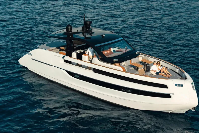  Yacht Photos Pics 2025 Invictus TT550 yacht cruising on open water with passengers relaxing on deck.