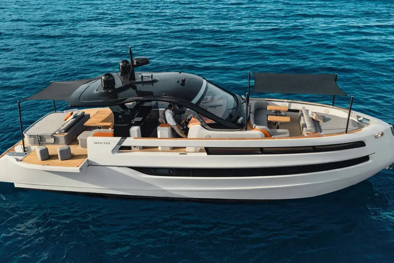  Yacht Photos Pics Luxury 2025 Invictus TT550 yacht cruising on clear blue ocean waters.