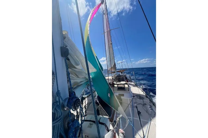  Yacht Photos Pics Sailing on a 1985 Robert Clark Ketch with colorful sails against a clear blue sky.