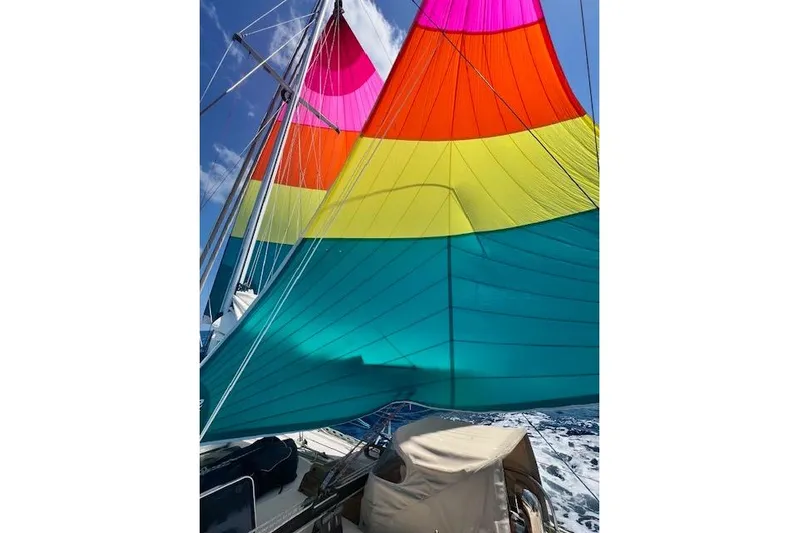  Yacht Photos Pics Colorful sails on a 1985 Robert Clark Ketch against a clear blue sky.