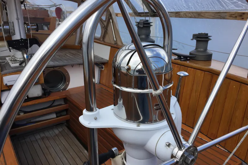  Yacht Photos Pics Steering wheel and compass on 1985 Robert Clark Ketch sailboat deck.