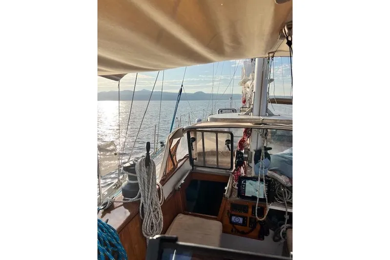  Yacht Photos Pics 1985 Robert Clark Ketch sailing on calm waters with scenic mountain view.