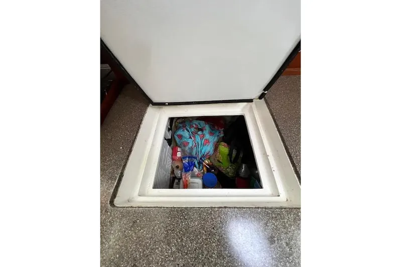  Yacht Photos Pics Storage compartment on 1985 Robert Clark Ketch, filled with various items and supplies.