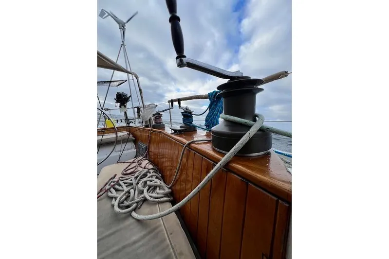  Yacht Photos Pics Deck view of 1985 Robert Clark Ketch sailboat with ropes and winch under cloudy sky.