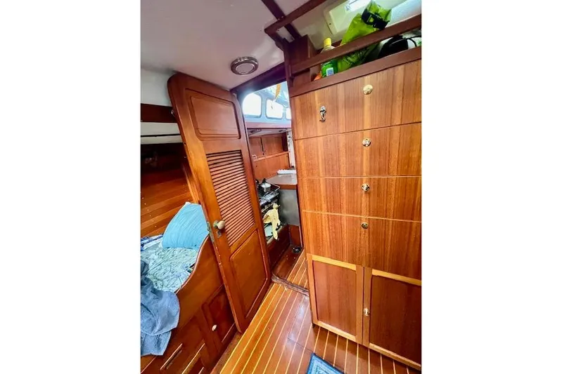  Yacht Photos Pics Interior of 1985 Robert Clark Ketch with wooden cabinetry and cozy sleeping area.