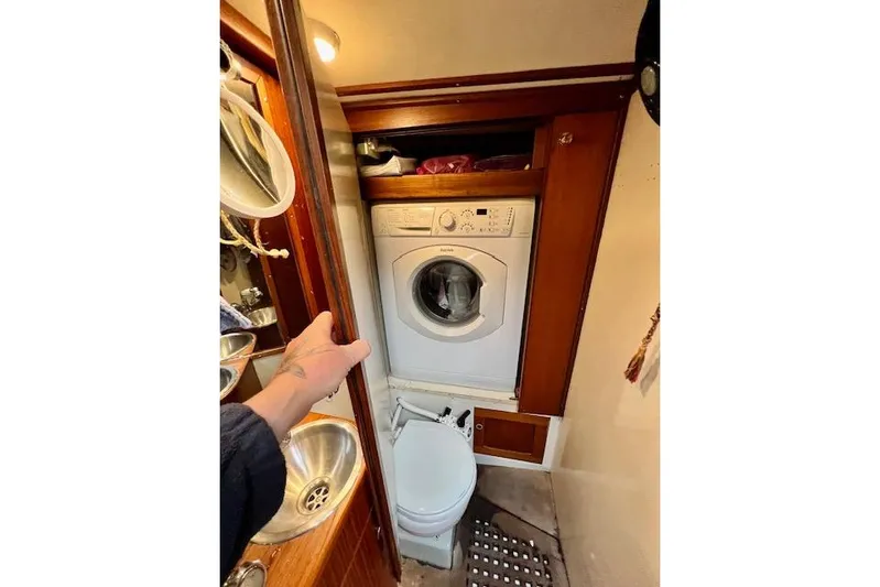  Yacht Photos Pics Compact bathroom with washer and toilet on 1985 Robert Clark Ketch sailboat.