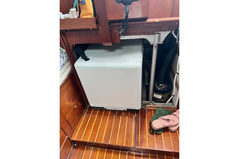  Yacht Photos Pics Compact washing machine in 1985 Robert Clark Ketch interior with wooden flooring.