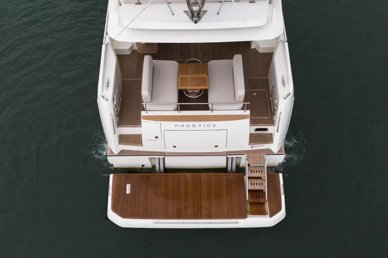  Yacht Photos Pics Rear view of 2026 Prestige F4.9 yacht with wooden deck and seating area.