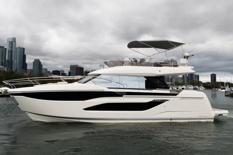  Yacht Photos Pics Luxury Prestige F4.9 yacht, 2026 model, cruising near city skyline under cloudy skies.