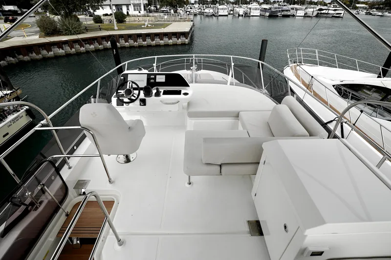  Yacht Photos Pics Luxurious 2026 Prestige F4.9 yacht deck with seating and steering, docked at marina.
