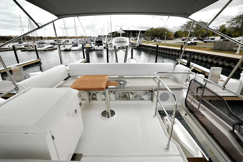  Yacht Photos Pics Luxurious 2026 Prestige F4.9 yacht deck with seating and table, docked at marina.