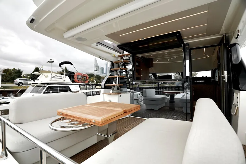  Yacht Photos Pics Luxurious 2026 Prestige F4.9 yacht interior with modern seating and wooden table.