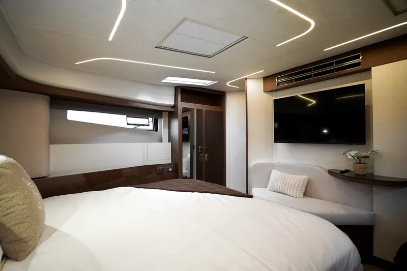  Yacht Photos Pics Luxurious Prestige F4.9 2026 yacht bedroom with modern design, ambient lighting, and flat-screen TV.