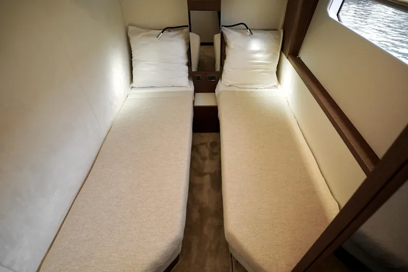  Yacht Photos Pics Twin beds in a 2026 Prestige F4.9 yacht cabin, featuring modern lighting and cozy bedding.