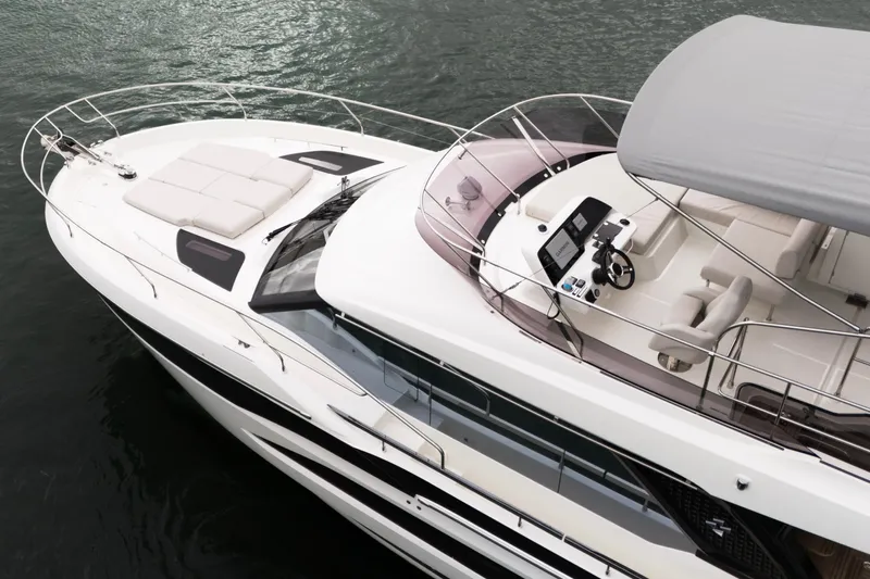  Yacht Photos Pics Luxurious 2026 Prestige F4.9 yacht with spacious deck and modern helm, cruising on water.