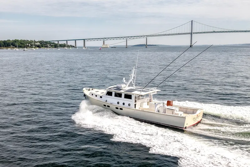 Stella Rose Yacht Photos Pics 2021 Mussel Ridge Downeast boat cruising near a large bridge on a sunny day.
