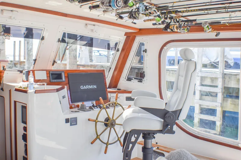 Stella Rose Yacht Photos Pics 2021 Mussel Ridge Downeast boat interior with Garmin navigation, fishing rods, and captain's chair.