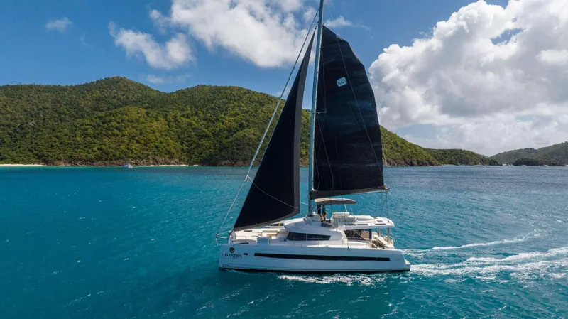 Ad Astra Yacht Photos Pics Sailing catamaran Bali 5.4, 2020 model, cruising in turquoise waters near lush green islands.