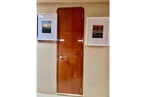 Play It Again Yacht Photos Pics Wooden cabin door on 2001 Sea Ray Sundancer 540 yacht, flanked by framed photos.