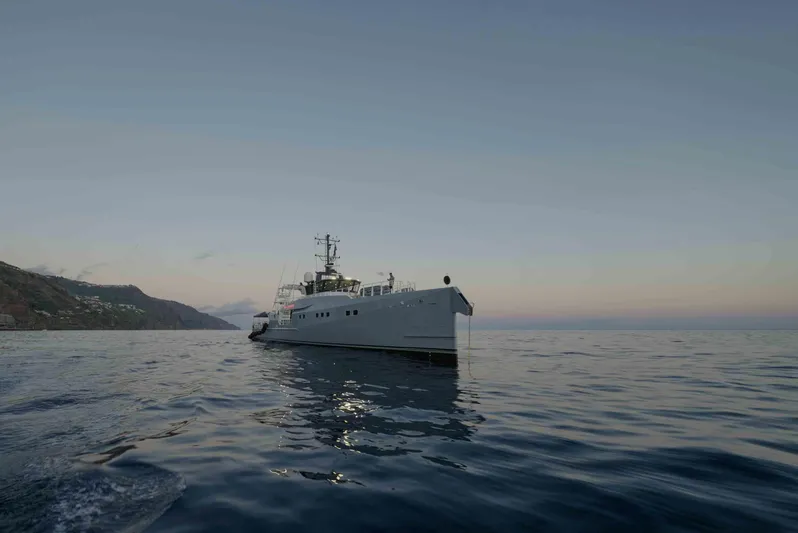 Bad Company Support Yacht Photos Pics Damen YS 4508 yacht on calm sea at sunset.