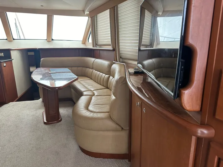  Yacht Photos Pics Interior of 2006 Silverton 48 Convertible yacht with leather seating and wooden table.