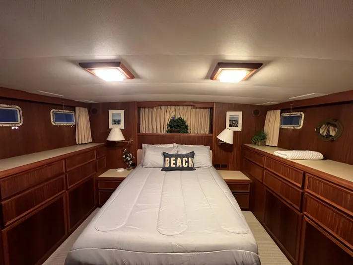 Wanderer Yacht Photos Pics Cozy bedroom in 1981 Hatteras 48 Motor Yacht with wood paneling and nautical decor.