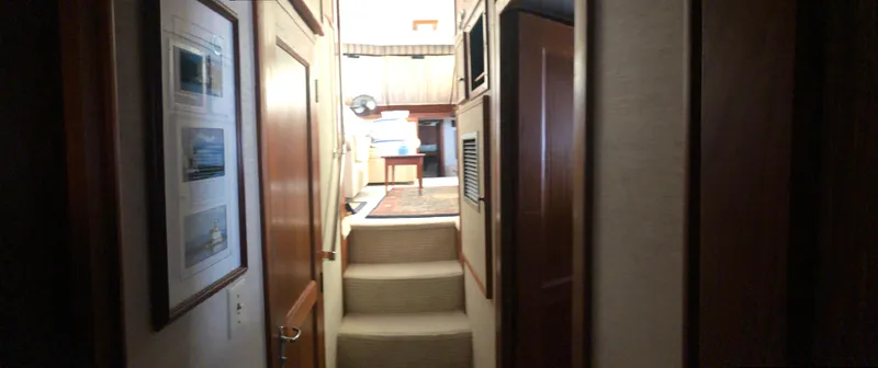 Wanderer Yacht Photos Pics Interior hallway of 1981 Hatteras 48 Motor Yacht with carpeted steps and wooden paneling.